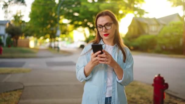 Happy Woman Using Smartphone While Standing Green Street Sunny Summer — Wideo stockowe