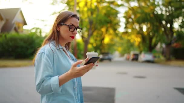 Happy Woman Smartphone Coffee Her Hands Walking Neighborhood Summer Evening — Stok video