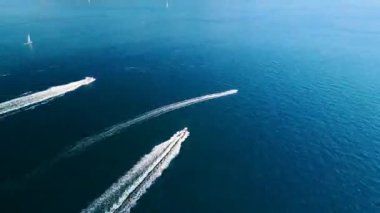 Derin mavi denizde beyaz dalgalı üç hızlı teknenin hava görüntüsü. Drone 'dan deniz burnu. Seyahat videosu. Hızlandırılmış video