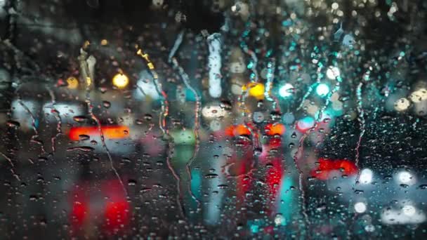 Kolorowe Światła Wieczornego Miasta Przejeżdżające Samochody Przez Wilgotne Deszczowe Okno — Wideo stockowe