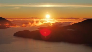 Vancouver 'ın kuzeyindeki güzel günbatımında deniz manzarası. Howe 'daki fiyortlar. Dağların siluetlerinin üzerine güneş batıyor. British Columbia, Kanada.
