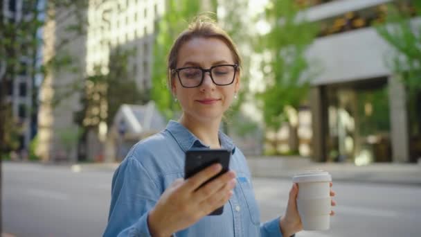 Biała Kobieta Okularach Stoi Ulicy Używa Smartfona Pije Kawę Strzał — Wideo stockowe