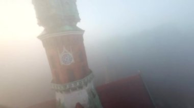 St. Josephs Kilisesi ve Podgorski Meydanı üzerinde yoğun sabah sisi içinde çevik uçuş. Krakow, Polonya. Manevra yapılabilir uçuş FPV İHA 'sı tarafından filme alındı.