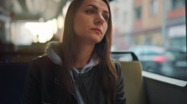 Toplu taşıma. Tramvayda akıllı telefon kullanan, arkadaşlarıyla mesajlaşan bir kadın. Şehir, şehir, ulaşım. Yavaş çekim