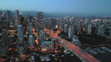 Geceleri Vancouver 'ın merkezindeki göz kamaştırıcı hava manzarası. Gökdelenler ve yollardaki trafik. British Columbia, Kanada. 