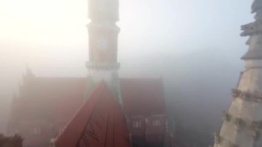 St. Josephs Kilisesi ve Podgorski Meydanı üzerinde yoğun sabah sisi içinde çevik uçuş. Krakow, Polonya. Manevra yapılabilir uçuş FPV İHA 'sı tarafından filme alındı.