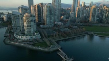 Şehir merkezindeki gökdelenlerin, False Creek 'in ve gün batımında dağların havadan görüntüsü. Vancouver, British Columbia, Kanada.