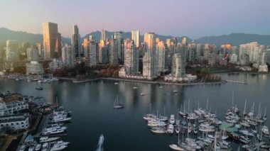 Şehir merkezindeki gökdelenlerin, dağların, False Creek 'in, tekneli marinanın havadan görüntüsü. Vancouver, British Columbia, Kanada, gün batımında.