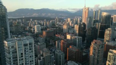 Şafak vakti Vancouver şehir merkezindeki gökdelenlerin hava görüntüsü. Dağlar arka planda görünür. British Columbia, Kanada.