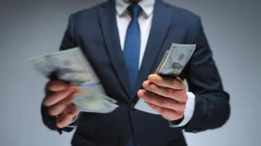 Resmi olarak giyinmiş adam Amerikan dolarlarını sayıyor, yakın plan. Yatırım, başarı, finansal beklentiler veya kariyer ilerlemesi kavramı.