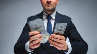 Resmi olarak giyinmiş adam Amerikan dolarlarını sayıyor, yakın plan. Yatırım, başarı, finansal beklentiler veya kariyer ilerlemesi kavramı.