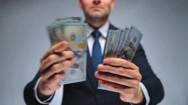 Resmi olarak giyinmiş adam Amerikan dolarlarını sayıyor, yakın plan. Yatırım, başarı, finansal beklentiler veya kariyer ilerlemesi kavramı.