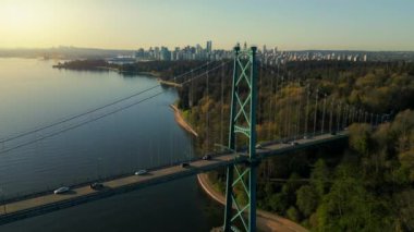Şafakta Lions Gate Köprüsü ve Stanley Parkı 'nın havadan görüntüsü. Arka planda Vancouver şehir merkezi var. Britanya Kolombiyası Kanada.