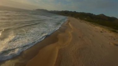 FPV İHA 'sı İtalya' nın Sardunya kıyıları boyunca Akdeniz sahillerinde hızla uçuyor. Çarpıcı gün batımı