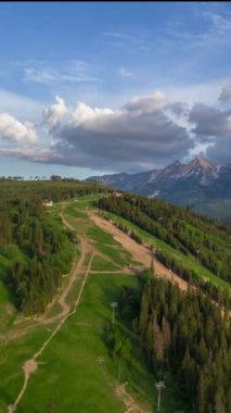 Etraftaki güzel Tantra dağlarının, bulutların ve manzaranın nefes kesen yüksek hızları. Orman, çayırlar ve yeşil çimenler. Lapszanka, Tatra dağları, Polonya. Dikey video