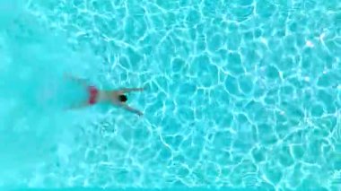 Bir adam havuza dalıp yüzerken yukarıdan aşağıya doğru bak.. 