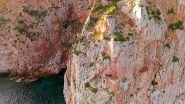 Porto Flavia 'nın insansız hava aracı fotoğrafı İtalya' da Sardunya sahilinde terk edilmiş bir mineral deposu iskelesinde..