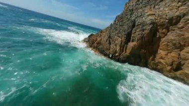 Deniz kıyısında kayalara ve suya yakın çevik bir uçuş. Güney Sardunya, İtalya. FPV insansız hava aracı tarafından filme alındı.