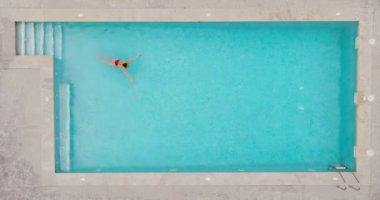 Top down view of a woman in red swimsuit swimming in the pool. Summer lifestyle.