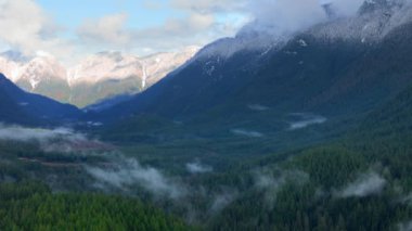 Kışın çarpıcı dağ manzarasının havadan görünüşü. Dağlar kar ve bulutlarla kaplıdır. Vancouver, British Columbia, Kanada yakınlarında çekilmiş..