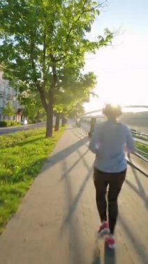 Kadın şafak vakti setin kenarına doğru koşuyor. Sabahın erken saatlerinde, boş şehir. Olağandışı görüntü, FPV insansız hava aracı ile çekildi. Ağır çekim. Dikey video