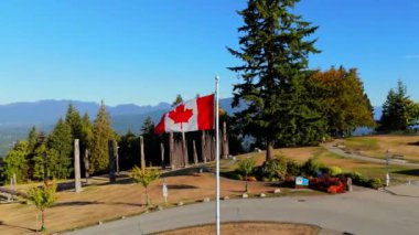 Burnaby Dağ Parkı 'nda Kanada Günü' nde Kanada bayrağının dalgalandığını gösteren hava yörüngesi çekimi. Vancouver, British Columbia, Canada, Kuzey Amerika