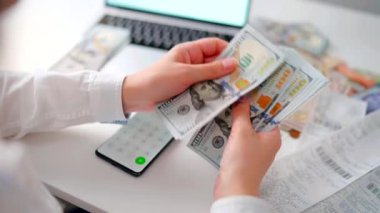 Aylık ev giderleri, vergiler, banka hesap bakiyesi ve kredi kartı faturaları hesaplayan bir kadın. Giderler için gelir yeterli değil.