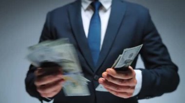 Mutlu giyinmiş adam Amerikan Doları 'nın faturalarını hızlı bir şekilde sayıyor. Yatırım, başarı, finansal beklentiler veya kariyer ilerlemesi kavramı.