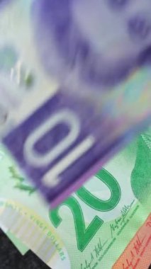 Karmaşık tasarımı ve çeşitli güvenlik özelliklerini vurgulayan farklı para birimleri ve mezheplerin yakın ve ayrıntılı görünümü. Dikey video