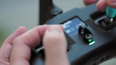 FPV drone operatörü, yakın plan, uzaktan kumandayı tutan eller.