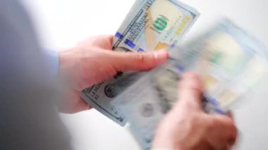 Erkek eller Amerikan dolarlarını sayıyor, yakın plan. Yatırım, başarı, finansal beklentiler veya kariyer ilerlemesi kavramı.