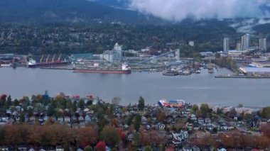 Kuzey Vancouvers limanı, geniş şehir, Vancouver limanı ve dağlarda uzanan bulutları gösteren hava manzarası. British Columbia, Kanada,