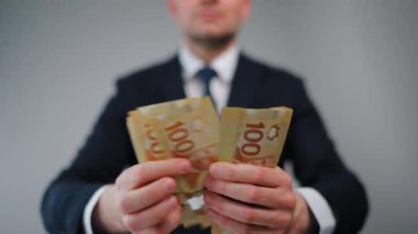 Resmi olarak giyinmiş adam Kanada Doları 'nı sayıyor, yakın plan. Yatırım, başarı, finansal beklentiler veya kariyer ilerlemesi kavramı. 