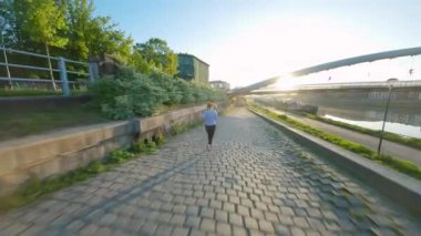 Kadın şafak vakti setin kenarına doğru koşuyor. Sabahın erken saatlerinde, boş şehir. Olağandışı görüntü, FPV insansız hava aracı ile çekildi. Yavaş çekim