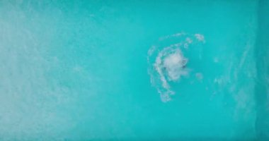 Bir adam havuza dalıp yüzerken yukarıdan aşağıya doğru bak.. 