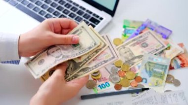 Aylık ev giderleri, vergiler, banka hesap bakiyesi ve kredi kartı faturaları hesaplayan bir kadın. Giderler için gelir yeterli değil.