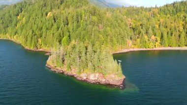 Kanada 'da göz kamaştırıcı sonbahar manzarası, British Columbia. Dağ yamaçlarındaki renkli ormanın ve bulutlu gökyüzünün havadan görünüşü. 