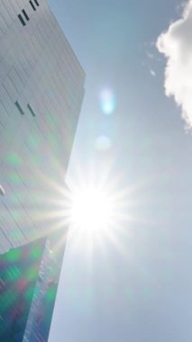 Büyük bir ofis binasının camına yansıyan bulutların zaman akışı. Modern gökdelenlerdeki bulutların yansıması. Cam yansımalı modern iş binaları. 