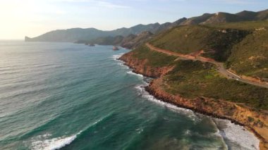 Güzel sahil manzarası, turkuaz suların üzerinde yükselen kıyı kayalıkları. Güney Sardunya, İtalya. 