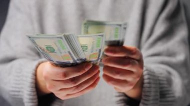 Amerikan Doları 'nı sayan bir kadın, yakın plan. Yatırım, başarı, finansal beklentiler veya kariyer ilerlemesi kavramı.