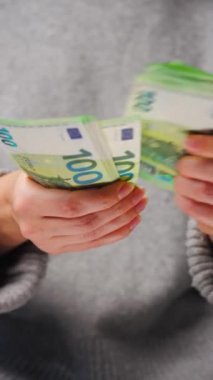 Avro banknotlarını sayan bir kadın, yakın plan. Yatırım, başarı, finansal beklentiler veya kariyer gelişimi kavramı. Dikey video