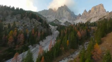 FPV insansız hava aracı tarafından çekilen bulutlu yüksek dağ sırasının havadan görüntüsü. Dolomites, İtalya 'daki Cristallo Dağı. Güzel sonbahar manzarası