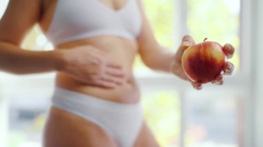Bir kadın elinde bir elma tutuyor. Sağlıklı beslenme ve sindirim kavramı