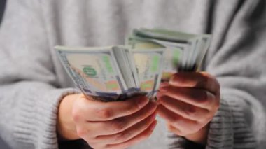 Amerikan Doları 'nı sayan bir kadın, yakın plan. Yatırım, başarı, finansal beklentiler veya kariyer ilerlemesi kavramı.