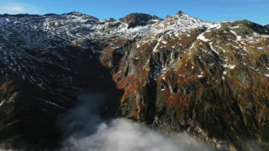 Güzel sonbahar dağ manzarası ve vadide uçan beyaz bulutlar. Alpler, Avusturya