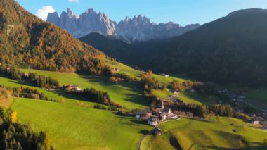 Funes Vadisi 'nin ikonik Chiesa di Santa Maddalena' yı gösteren panoramik manzarası. Arka planda, İtalyan Alplerindeki ünlü Dolomite Dağları