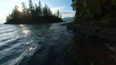 Kanada 'da göz kamaştırıcı sonbahar manzarası. Dağ yamaçlarındaki renkli ormanın havadan görünüşü ve Harrison Gölü, British Columbia. FPV insansız hava aracı tarafından çekildi.