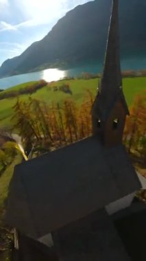 Güney Tyrol, Curon Venosta, İtalya 'daki Reschensee yapay gölünün suyundan yükselen Graun' un ikonik eski kilise kulesinin etrafında hızlı bir çevik uçuş. FPV insansız hava aracı tarafından filme alındı.