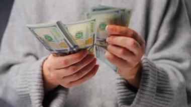 Amerikan Doları 'nı sayan bir kadın, yakın plan. Yatırım, başarı, finansal beklentiler veya kariyer ilerlemesi kavramı.