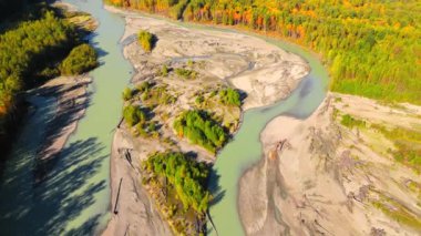 Kanada 'da göz kamaştırıcı sonbahar manzarası, British Columbia. Dağ yamaçlarındaki renkli ormanın ve vadideki nehrin havadan görünüşü